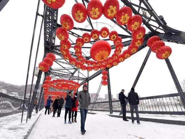 2月12日,在兰州市中山桥,游客在雪中游览.